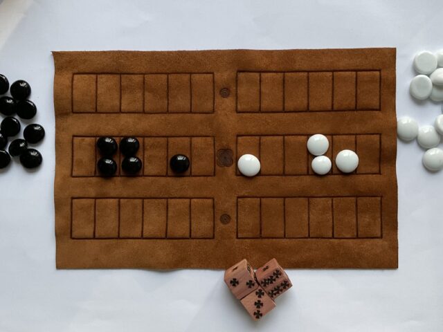 Replica unui celebru joc antic, precursorul jocului de table. Realizat din materiale organice: piele naturală, sticlă, lemn.